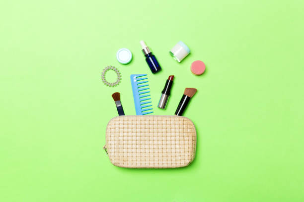 top view od cosmetics bag with spilled out make up products on green background. beauty concept with empty space for your design - pampering nail polish make up spilling imagens e fotografias de stock