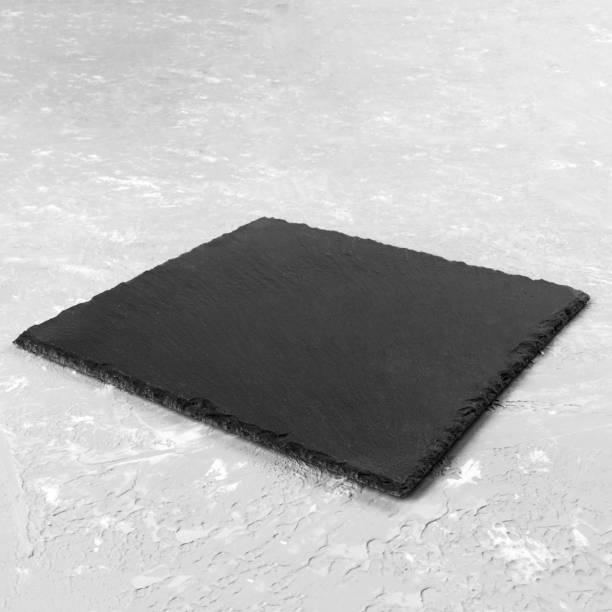 istock square plate on table. black dish on gray cement background. copy space 1169704648