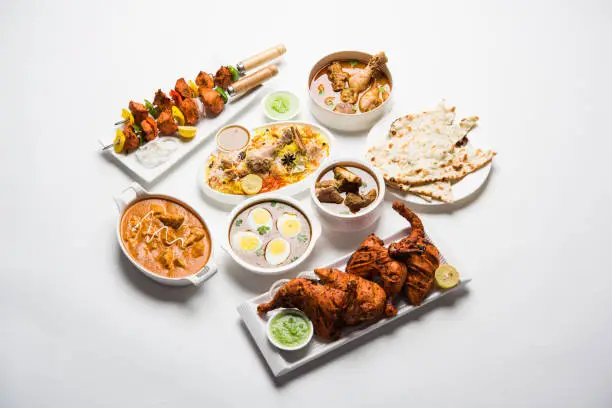 Photo of Assorted Indian Non Vegetarian food recipe served in a group. Includes Chicken Curry, Mutton Masala, Anda/egg curry, Butter chicken, biryani, tandoori murg, chicken-tikka and naan/roti