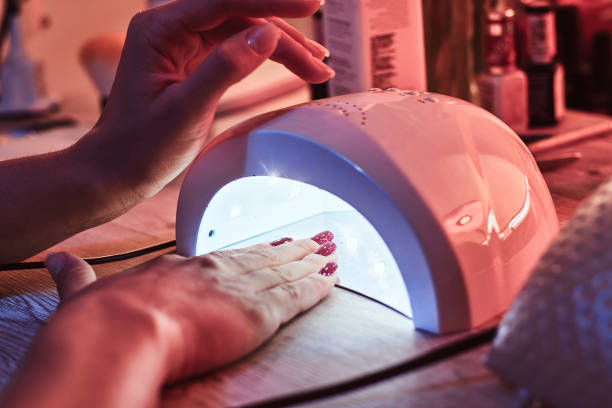 istock Client at manicure salon dryes gel nails in UV light 1169711026