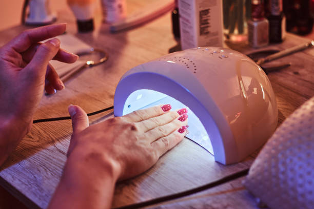 istock Client at manicure salon dryes gel nails in UV light 1169711086