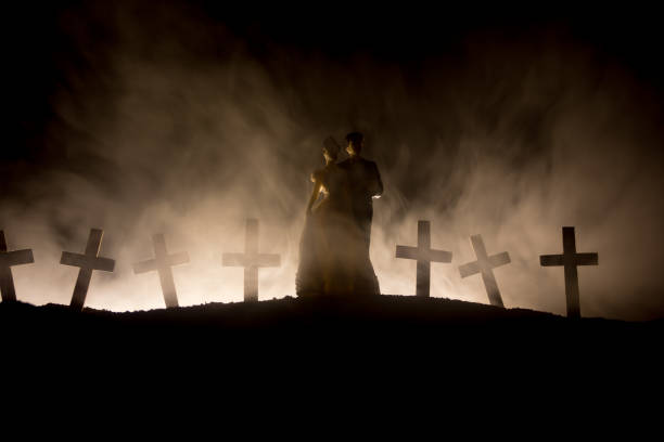 istock Halloween. Scary zombie bride on a night cemetery holds a pumpkin lantern. 1169711495