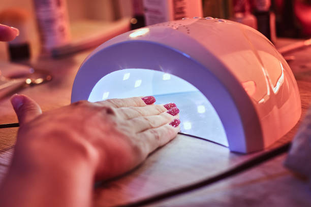 istock Client at manicure salon dryes gel nails in UV light 1169711637