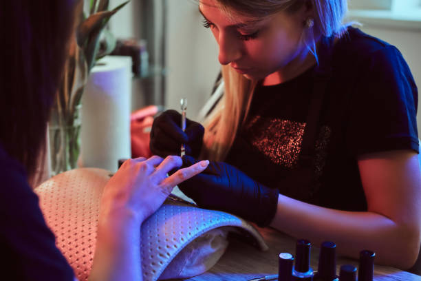 istock Manicure specialist is doing nail care for client at beauty salon. 1169712207