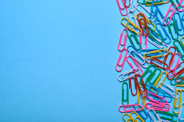 istock Colorful paper clips on blue pastel texture, copy space. Top view, flat lay. Back to school, business, education concept. Abstract background 1169712378