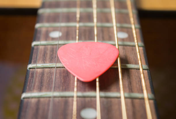 istock Red Pick on Acoustic Guitar String in Zoom View 1169713280