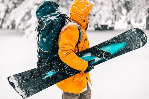 istock Man exploring mountain, choosing track for snowboarding 1169714055
