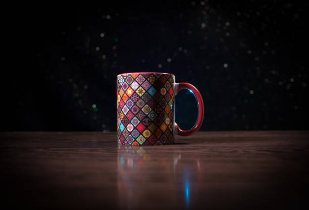 Beautiful eastern style textured ceramic cup of coffee (or tea) with smoke over dark toned background.