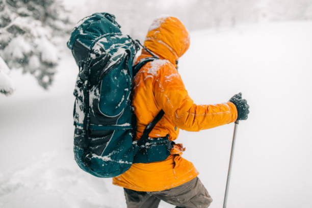 Man exploring mountain, hiking with backpack on his back