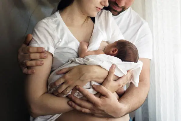 Photo of Father and mother with a newborn son. New young multi-generation family