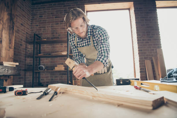istock Portrait of his he nice handsome blond focused guy artisan builder woodworker grinding hard wood at industrial brick loft style interior workplace indoors 1169717691