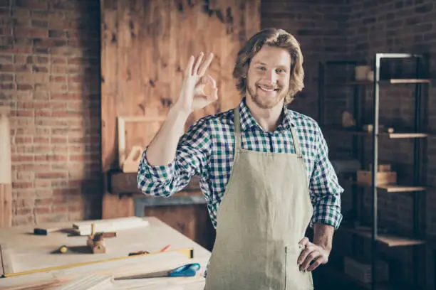 Portrait of his he nice attractive handsome cheerful cheery guy small business, shop owner showing ok-sign recommend at industrial brick loft style interior indoors workplace