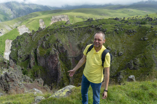 istock A man stands on the edge of the gorge and enthusiastically says something. 1169717841