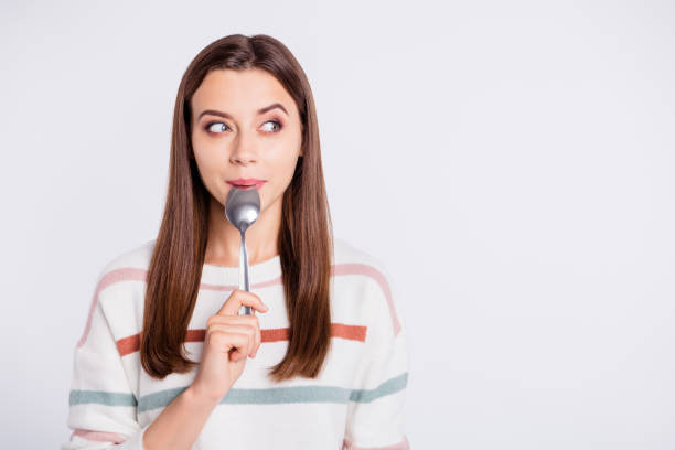 very hungry lady holding spoon into mouth dream of tasty meal wear striped pullover isolated white background - eating utensil elegance silverware fine dining imagens e fotografias de stock