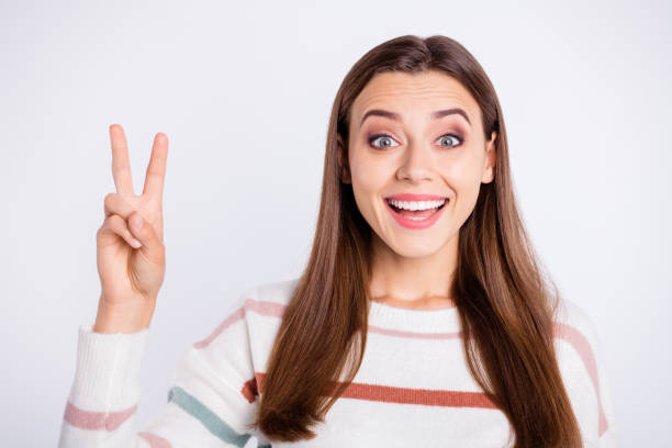 istock Pretty lady showing v-sign symbol wear striped pullover isolated white background 1169724835