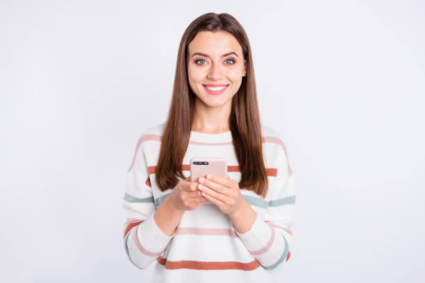 istock Pretty lady holding telephone hands wear striped fluffy pullover isolated white background 1169724897