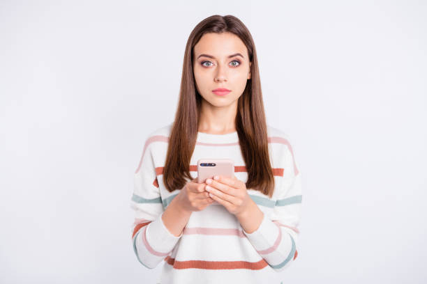 istock Pretty lady holding telephone hands not smiling wear striped fluffy pullover isolated white background 1169724922