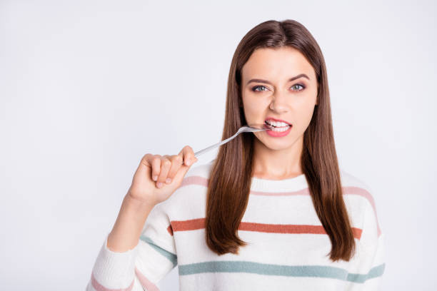 istock Pretty lady can't stand keeping to diet biting metal spoon wear striped pullover isolated white background 1169724939