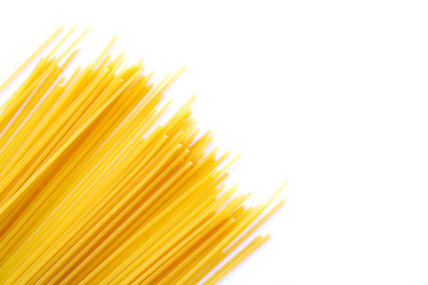 spaghetti pasta auf weißem hintergrund - pasta raw traditional culture heap stock-fotos und bilder