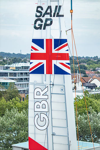 Southampton, England - August 4th, 2019 - Close up of Great Britain’s High performance multihull catamaran racing yacht sail. The boat is being lifted from the water onto the key. Hydrofoils allow boats to 'fly' across the water when at top speed. Reaching speeds in excess of 50mph!