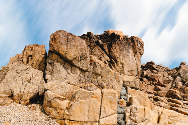 rock formation against sky in sillon de talbert area - long exposure rock cloud sky photos et images de collection