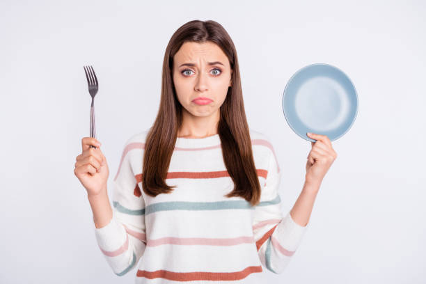 istock Hungry lady holding fork and empty plate want more for supper wear striped pullover isolated white background 1169725806