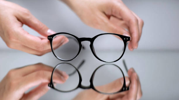 istock Female hands taking corrective eyeglasses prescribed by optometrist, optics 1169729060