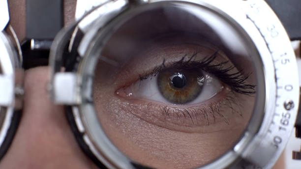 close-up female eye in optical trial frame, lens selection, vision checking - close up medical test exam people imagens e fotografias de stock