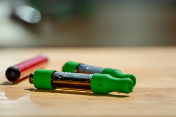 Marijuana vape kit with red vape pen and THC CBD oil cartridges. stock photo