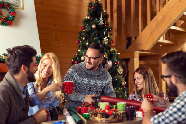 istock Friends wrapping Christmas presents and drinking coffee 1169731526