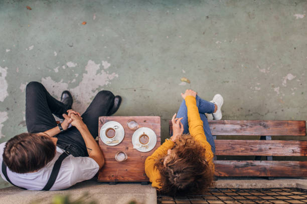 istock Young couple sitting in sidewalk cafe 1169731565