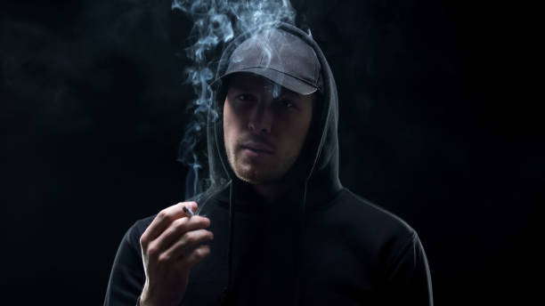 istock Gangster in black holding cigarette and looking camera, banditry racketeering 1169733555