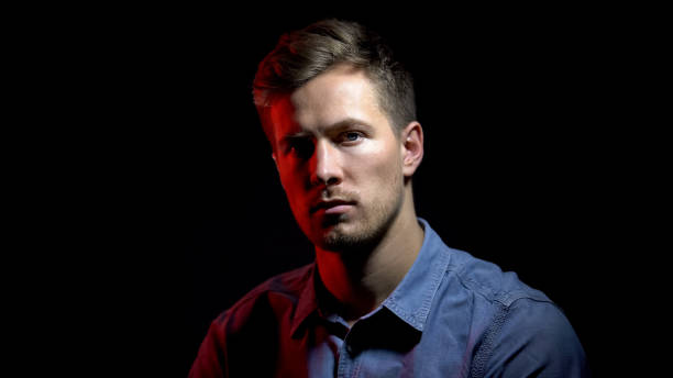 istock Pensive male under dark-red and white light, split personality, psychology 1169733561