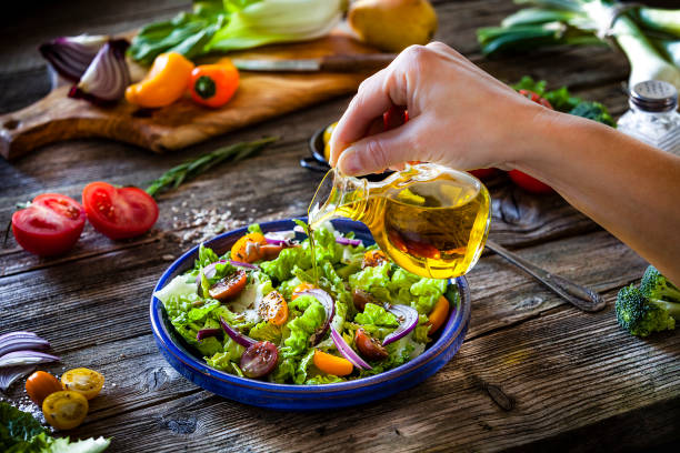 istock Dressing fresh organic vegetables salad with olive oil 1169736103