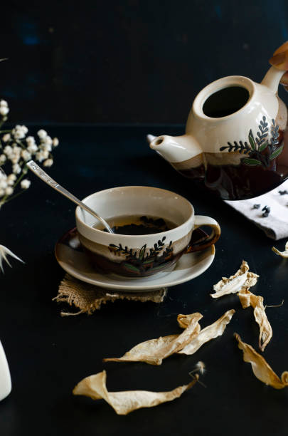 istock woman hand holding teapot 1169736567