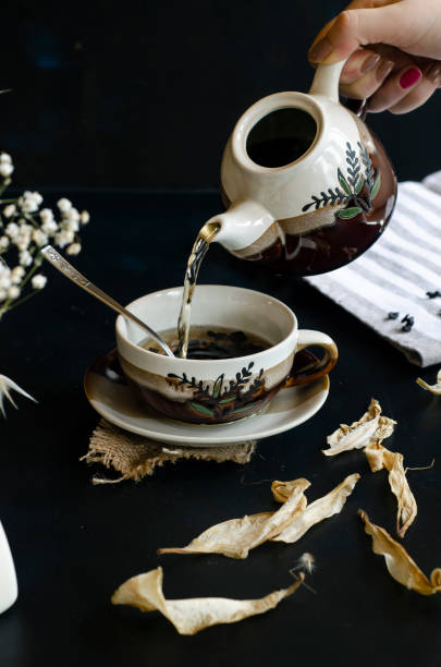 istock woman hand holding teapot 1169737276