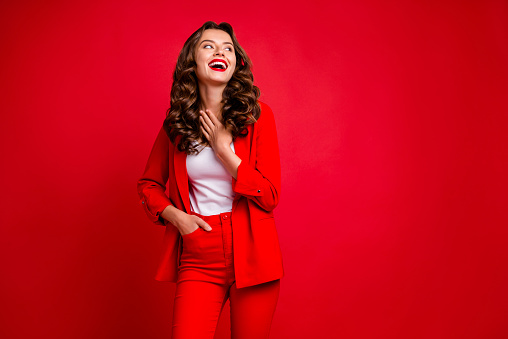 Portrait of lovely lady touching, her chest looking up isolated over red background