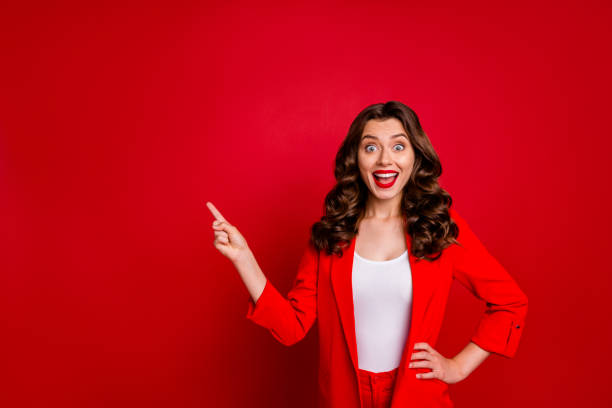 istock Beautiful lady indicating empty space on black friday prices dressed formal-wear costume isolated burgundy background 1169738751