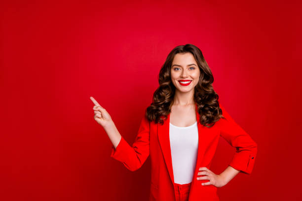 Beautiful lady indicating empty space on black friday prices dressed formal-wear costume isolated burgundy background