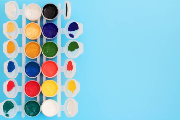 istock Multi-colored paint in cans on blue background. Palette of colors. Concept - creativity and school theme. 1169738907