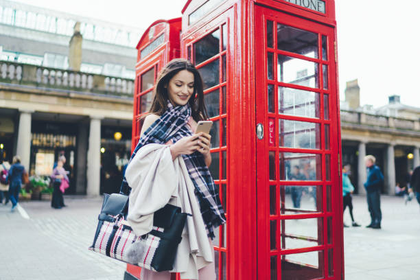 empresaria en reino unido/londres enviando mensajes de texto en la ciudad - london england business telephone booth commuter fotografías e imágenes de stock