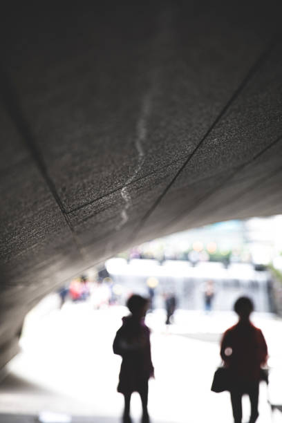 istock Defocused people walk under a bridge in the city 1169743776