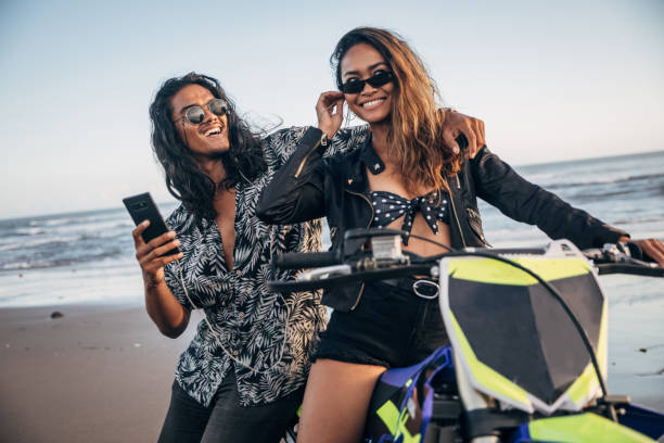 istock Young couple using phone together by the sea 1169745017