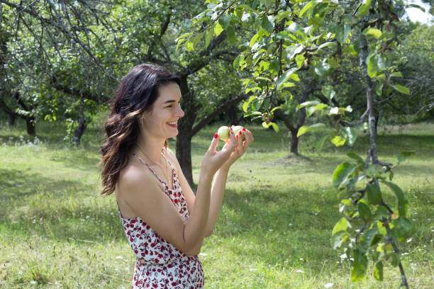 istock Happy woman walks in the apple orchard. 1169745132