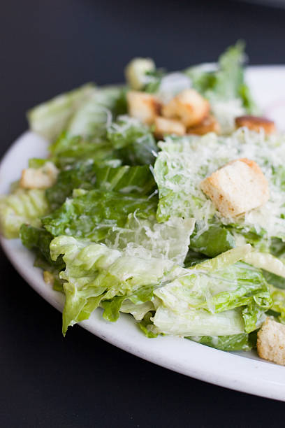 fresh salad in plate and ingredients on table