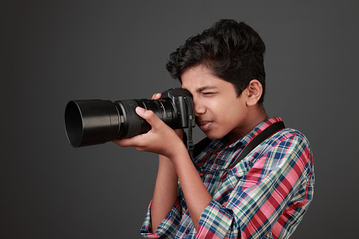Young boy looks through a camera