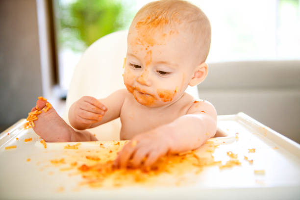 istock A Little baby eating her dinner and making a mess 1169745458