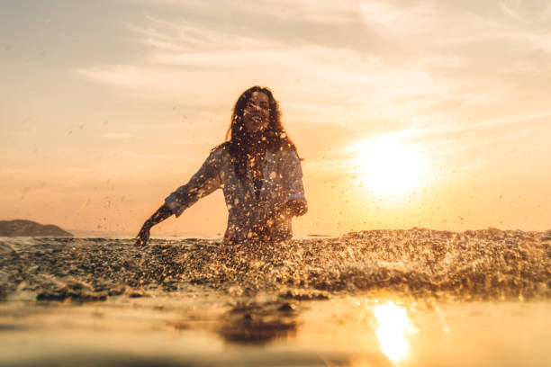Young pretty caucasian woman in sea sprinkle camera, having fun. POV concept.