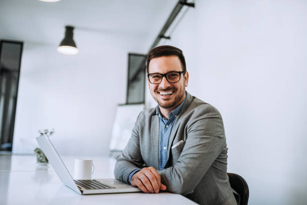 istock Cheerful businessman with glasses in bright office. 1169748106