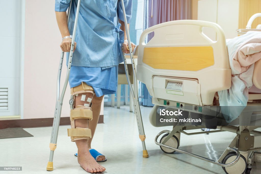 https://media.istockphoto.com/id/1169748223/photo/patient-standing-on-crutch-in-hospital-ward-ware-knee-brace-support-after-do-posterior.jpg?s=1024x1024&w=is&k=20&c=-iXkB1Zvq0wNOUXp6CJq0VzB61phZwpdSb1EQMI0Zh8=